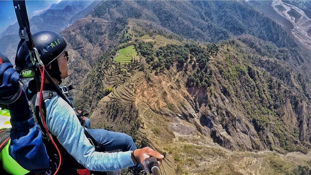Tandem paragliding adventure over scenic mountains in Kamshet, India, offering a thrilling aerial experience.
